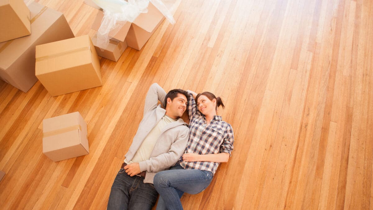 młoda para leży na podłodze w swoim nowym mieszkaniu